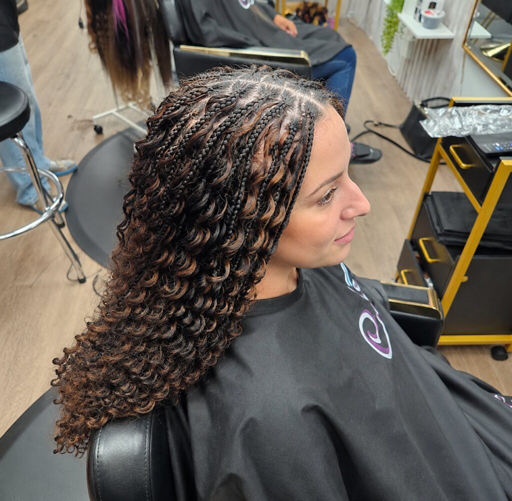 Knotless braids with curly boho ends in a warm auburn